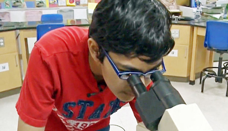 Tanishq Abraham dùng kính hiển vi tại Cao đẳng cộng đồng America River, bang California, Mỹ.